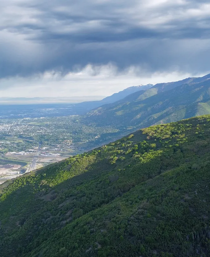Arial view of a green mountain overlooking a town